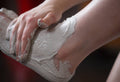 Volcano, a creamy grey coloured foot mask, is rubbed onto the top of a foot already coated in the mask from heel to toe.