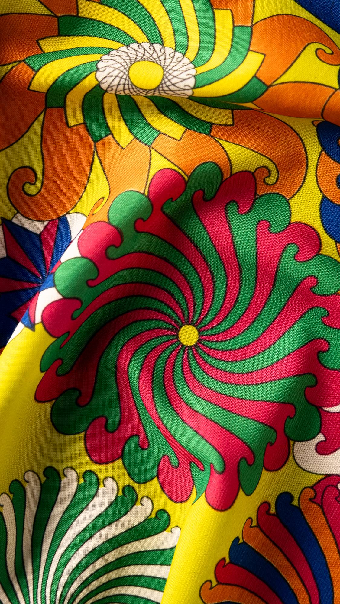 Image shows a super close-up of the Whirly Swirly knot wrap focusing on a bright pink and green pinwheel spiral.